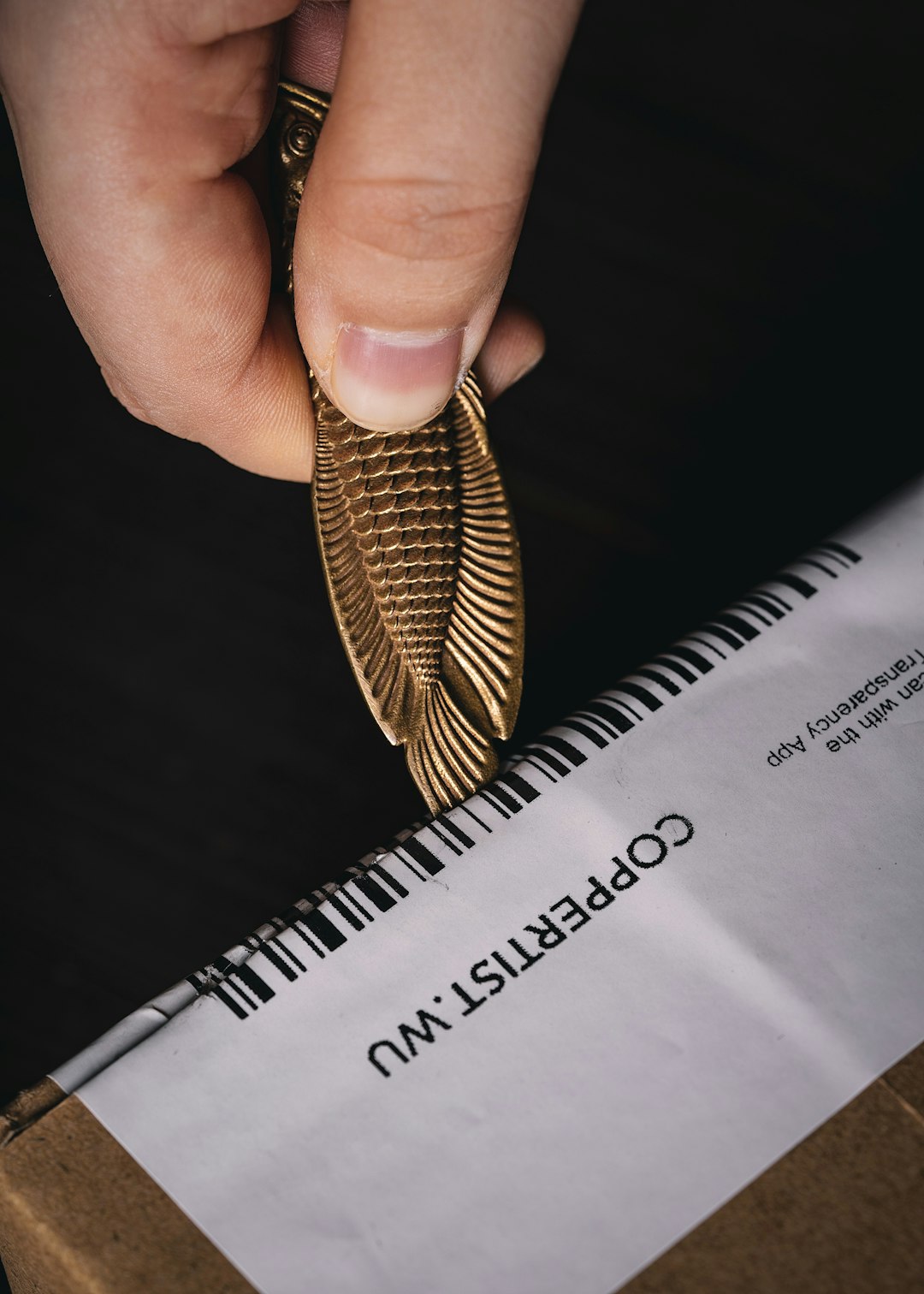 a person is holding a gold object in their hand