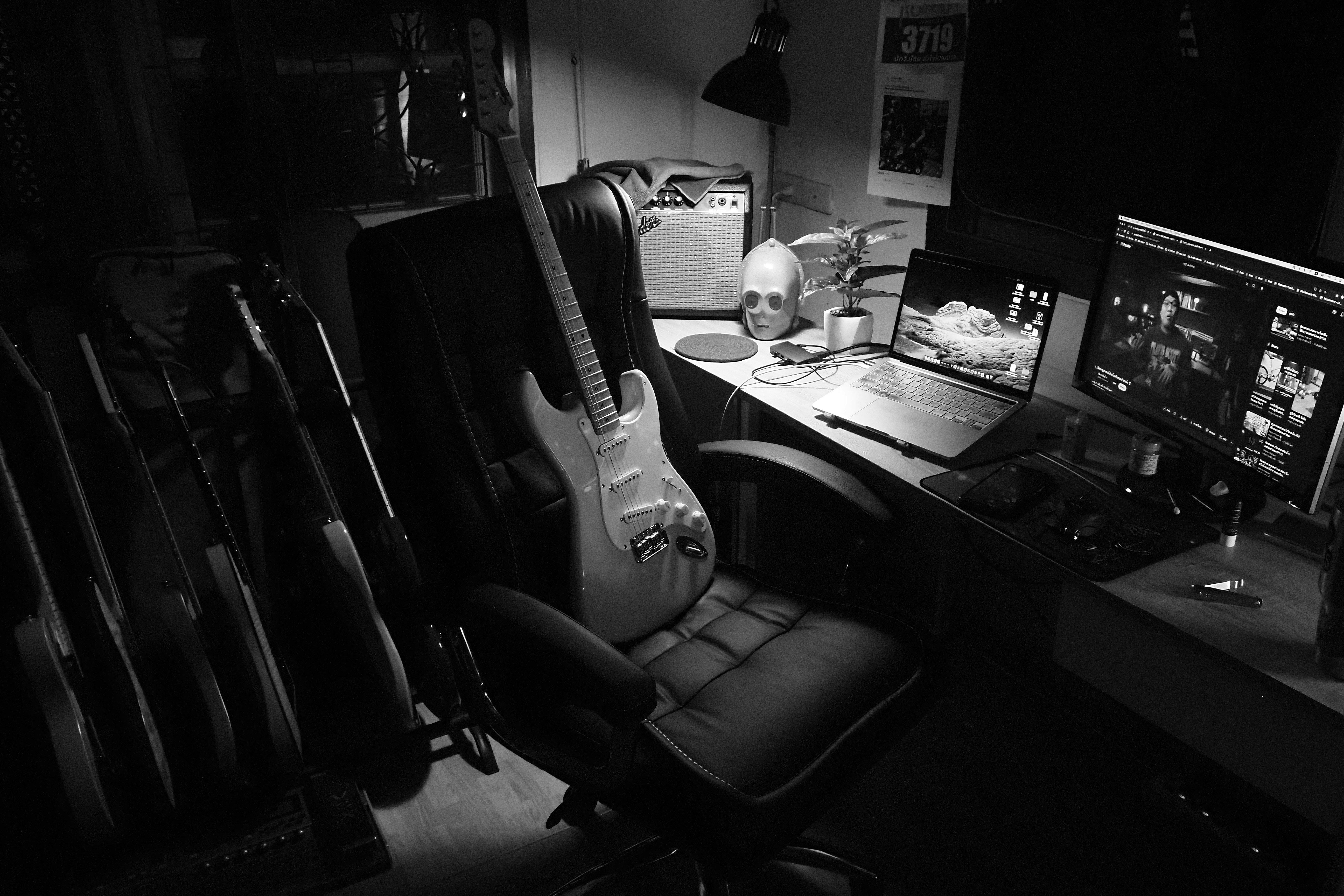 A black and white photo of a desk with a guitar